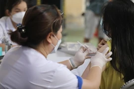 Nhân viên y tế tiêm vaccine cho học sinh. (Ảnh: Minh Quyết/TTXVN)