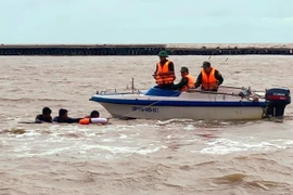 Lực lượng Bộ đội Biên phòng Cà Mau tiếp cận, cứu vớt 3 người trôi dạt trên biển đưa vào bờ an toàn. (Ảnh: TTXVN phát)