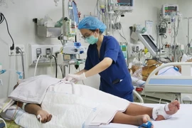 Nhân viên y tế của Khoa Cấp cứu-Hồi sức tích cực-Chống độc người lớn, Bệnh viện Bệnh Nhiệt đới Thành phố Hồ Chí Minh chăm sóc cho bệnh nhân sốt xuất huyết nặng. (Ảnh: Đinh Hằng/TTXVN)