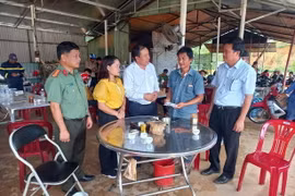 Chủ tịch UBND huyện Bù Đăng Vũ Văn Mười động viên, hỗ trợ gia đình nam thanh niên bị nước lũ cuốn trôi. (Ảnh: Đậu Tất Thành/TTXVN)