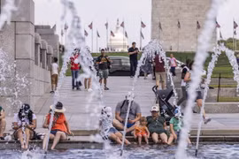 Người dân tránh nóng bên đài phun nước tại Washington, D.C., Mỹ, ngày 11/7 vừa qua. (Ảnh: THX/TTXVN)