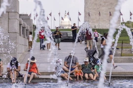 Người dân tránh nóng bên đài phun nước tại Washington, D.C., Mỹ, ngày 11/7 vừa qua. (Ảnh: THX/TTXVN)