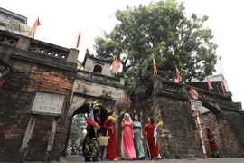 Các bà, các cô xúng xính áo dài đón năm mới bình an, hạnh phúc. (Ảnh: Nhật Anh/TTXVN)