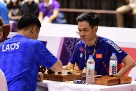 Kỳ thủ của Việt Nam (bên phải) thi đấu môn cờ ốc gặp kỳ thủ của Lào trong ngày ra quân 29/4. (Ảnh: Minh Quyết/TTXVN)