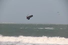 Người chơi lướt ván diều chuyên nghiệp nhào lộn trên không tại biển Mũi Né. (Ảnh: Nguyễn Thanh/TTXVN)