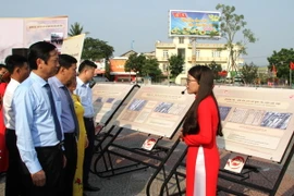 Các đại biểu xem và nghe thuyết minh về tại Triển lãm "Quảng Trị - Dấu ấn lịch sử qua tài liệu lưu trữ." (Ảnh: Nguyên Lý/TTXVN)