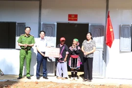 Chủ tịch UBND thành phố Lai Châu Nguyễn Văn Nghiệp và Thượng tá Hà Thái Hoàn, Trưởng Công an thành phố Lai Châu trao tặng nhà ở cho gia đình ông bà Giàng A Súa và Má Thị Tùng. (Ảnh: Đinh Thùy/TTXVN)