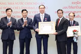 Ủy viên Bộ Chính trị Đảng Nhân dân Cách mạng Lào, Chủ tịch Ủy ban Trung ương Mặt trận Lào xây dựng đất nước Sinlavong Khoutphaythoune trao tặng Huân chương Itxala cho ông Phùng Khánh Tài nguyên Phó Chủ tịch Ủy ban Trung ương MTTQ Việt Nam, Phó Bí thư Thườ