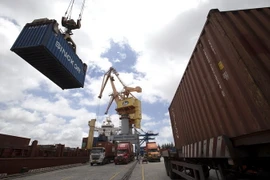 Các container được bốc xếp từ xe chở chuyên dụng lên tàu chở hàng. (Ảnh: Tuấn Anh/TTXVN)