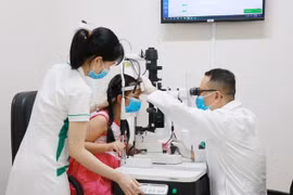 Bác sỹ chuyên khoa II Nguyễn Nam Trung thăm khám cho bệnh nhi đau mắt đỏ tại Bệnh viện Mắt Sài Gòn Nha Trang. (Ảnh: Phan Sáu/TTXVN)