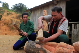 Nghệ nhân ưu tú A Gông (phải) truyền dạy kỹ năng tạc tượng gỗ của người Mơ Nâm cho thanh niên tại làng Kon Du, xã Măng Cành, huyện Kon Plông, tỉnh Kon Tum. (Ảnh: Khoa Chương/TTXVN)