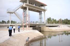 Cán bộ, nhân viên Công ty THHH Một thành viên Khai thác công trình thủy lợi Bến Tre kiểm tra vận hành cống Châu Thới, huyện Giồng Trôm. (Ảnh: Công Trí/TTXVN)