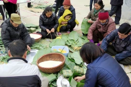 Gói bánh chưng ăn Tết cho gia đình. (Ảnh: Thu Hằng/TTXVN)