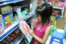 Lựa chọn những món quà mà bé yêu thích. (Ảnh: Thanh Tâm/Vietnam+)