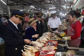 Nhân viên Chi cục Thú y kiểm tra cơ sở kinh doanh thịt gia cầm tại chợ. (Ảnh: Vũ Sinh/TTXVN)