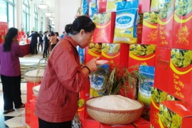 Người tiêu dùng kiểm tra chất lượng của gạo Lanny Rice. (Ảnh: Thanh Tâm/Vietnam+)