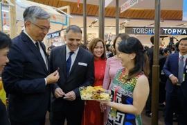 Các đại biểu dùng thử sản phẩm Tuần hàng Việt Nam tại Thái Lan. (Ảnh: PV/Vietnam+)