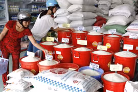 Người tiêu dùng mua gạo trên thị trường. (Ảnh: Đình Huệ/TTXVN)