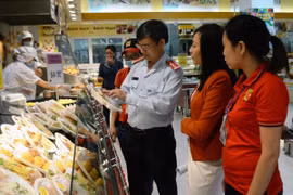 Đoàn thanh tra liên ngành kiểm tra các mặt hàng thực phẩm được bày bán tại siêu thị. (Ảnh: Quốc Dũng/TTXVN)