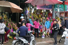 Các cửa hàng hoa tươi nhộn nhịp người mua dịp 8/3. (Ảnh: Nam Giang/Vietnam+)