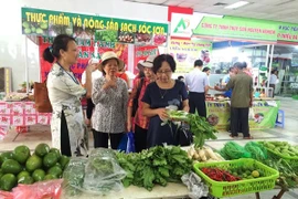 Gian hàng bày bán các sản phẩm rau an toàn thu hút đông người tiêu dùng lựa chọn. (Ảnh: Thanh Tâm/Vietnam+)