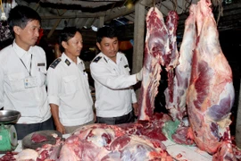Lực lượng thú y tăng cường kiểm tra thịt tươi sống tại các chợ. (Ảnh: Đình Huệ/TTXVN)