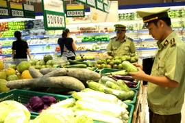 Lực lượng quản lý thị trường kiểm tra chất lượng thực phẩm tại siêu thị. (Ảnh: Vũ Sinh/TTXVN)