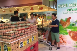 Người tiêu dùng lựa chọn mua trứng tại siêu thị. (Ảnh: Thanh Tâm/Vietnam+)
