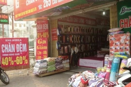 Các cửa hàng treo biển giảm giá sâu nhằm thu hút người mua (Ảnh: Quỳnh Trang/Vietnam+)