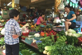 Người tiêu dùng mua rau tại chợ Hôm. (Ảnh: Thanh Tâm/Vietnam+)