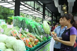 Người tiêu dùng lựa chọn sản phẩm rau an toàn tại siêu thị. (Ảnh: Thanh Vũ/TTXVN)