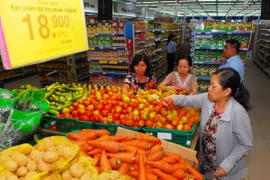 Người tiêu dùng lựa chọn thực phẩm an toàn tại siêu thị. (Ảnh: Mạnh Linh/TTXVN)