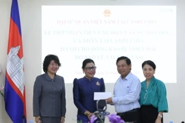 Bà Chea Sam Eng, đại diện thế hệ sinh viên là con em lãnh đạo cấp cao Campuchia học tập tại Việt Nam giai đoạn 1980-1987, trao số tiền quyên góp ủng hộ. (Ảnh: Huỳnh Thảo/TTXVN)