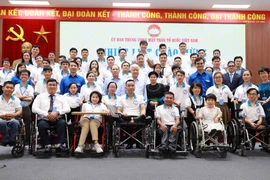 Chủ tịch Ủy ban Trung ương MTTQ Việt Nam Đỗ Văn Chiến cùng các thanh niên khuyết tật tiêu biểu. (Ảnh: Vân Chi/TTXVN phát)