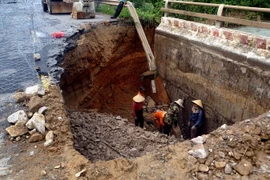 Đội ngũ cán bộ, công nhân viên Xí nghiệp Quản lý và sửa chữa Quốc lộ 14B thuộc Công ty Cổ phần Công trình Giao thông Vận tải, Sở Giao thông Vận tải tỉnh Quảng Nam đang khắc phục sạt lở trên cầu suối Mơ ở huyện Đại Lộc. (Ảnh: Trịnh Bang Nhiệm/TTXVN)