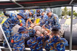 Cán bộ, chiến sỹ đảo Sinh Tồn đưa ngư dân vào đảo cấp cứu. 