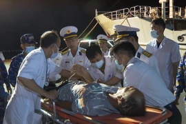 Lực lượng Hải quân đưa ngư dân bị bệnh lên bờ bàn giao cho người nhà và địa phương để đưa đi cấp cứu ở bến cảng ở tỉnh Khánh Hòa. (Ảnh: TTXVN phát)