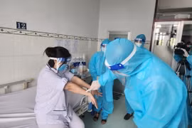 Lãnh đạo Cục Y tế dự phòng, Bộ Y tế thăm hỏi, động viên người bệnh mắc đậu mùa khỉ. (Ảnh: TTXVN phát)