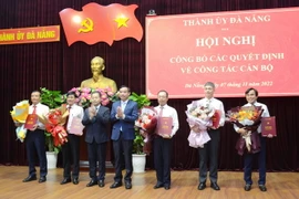 Bí thư Thành ủy Đà Nẵng Nguyễn Văn Quảng (thứ 3 từ trái sang) và Chủ tịch UBND thành phố Đà Nẵng Lê Trung Chinh (thứ 4 từ trái sang) trao quyết định và tặng hoa chúc mừng các cán bộ được điều động, luân chuyển. (Ảnh: Quốc Dũng/TTXVN)