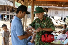 Nhân viên Quân y, Bộ chỉ huy Quân sự tỉnh Nghệ An thăm khám, cấp phát thuốc cho nhân dân vùng lũ ở huyện Kỳ Sơn. (Ảnh: Văn Tý/TTXVN)