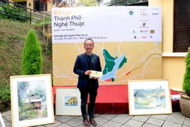 Anh Trần Trung Hiền, thành viên sáng lập viên của nhóm "Phố Bên Đồi" giới thiệu Bản đồ Nghệ thuật Đà Lạt. (Ảnh: Chu Quốc Hùng/TTXVN)