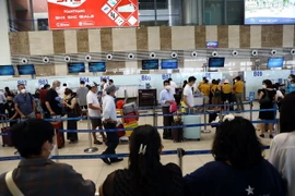 Hành khách xếp hàng vào làm thủ tục tại khu vực của hãng hàng không Vietnam Airlines tại Cảng Hàng không quốc tế Nội Bài. (Ảnh: Huy Hùng/TTXVN)