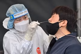 Nhân viên y tế lấy mẫu xét nghiệm COVID-19 cho người dân tại Seoul của Hàn Quốc. (Ảnh: AFP/TTXVN)