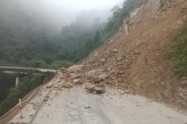 Hàng trăm khối đất, đá trên núi đổ xuống gây ách tắc trên tuyến Quốc lộ 8A, đoạn qua xã Sơn Kim 1. (Ảnh: TTXVN phát)
