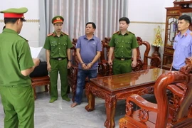 Cơ quan công an đọc lệnh bắt bị can Hoàng Văn Phi. (Ảnh: TTXVN phát)