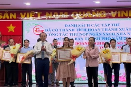 Lãnh đạo Thành ủy, UBND TPHồ Chí Minh trao tặng bằng khen cho đại diện doanh nghiệp thực hiện tốt công tác nộp ngân sách năm 2022. (Ảnh: Hứa Chung/TTXVN)