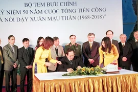 Bộ trưởng Bộ Thông tin và Truyền thông Trương Minh Tuấn ký phát hành bộ tem. (Ảnh: T.H/Vietnam+)