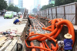 Thi công hạ ngầm tuyến cáp trên đường Lê Văn Lương. (Ảnh: Hồng Kỳ/TTXVN) 