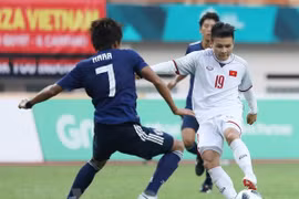 Tiền vệ Quang Hải (áo số 19) trong một pha tranh bóng với cầu thủ đội tuyển Olympic Nhật Bản. (Ảnh: Hoàng Linh/TTXVN) 