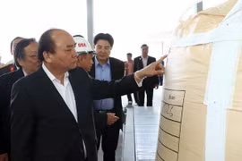 Thủ tướng Nguyễn Xuân Phúc xem sản phẩm của Nhà máy Alumin Nhân Cơ (tỉnh Đắk Nông). (Ảnh: Thống Nhất/TTXVN)